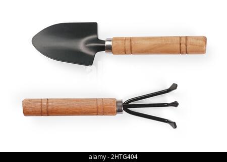 Small shovel and rake with wooden handle. Isolated on white, clipping path included Stock Photo