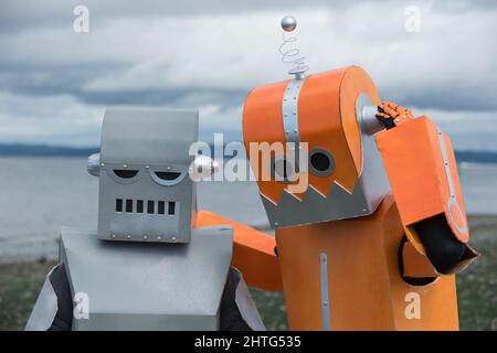Two robot friends hugging and dialing it in. Good robot friends. Or maybe robots in love. Stock Photo