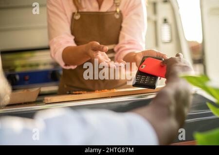 Crop man making payment for order in food truck Stock Photo