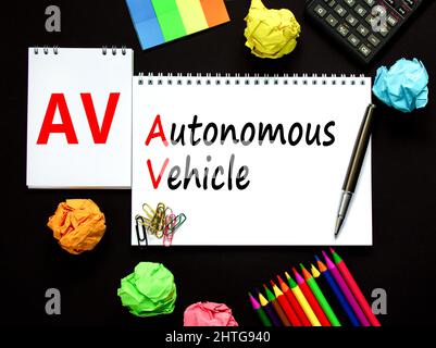 AV autonomous vehicle symbol. Concept words AV autonomous vehicle on white note. Metallic pen, calculator. Beautiful black background. Business techno Stock Photo