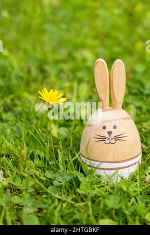 Easter Card with inscription happy Easter. Sunny green lawn with Easter decor, Wooden bunnies, greeting text. Spring time Stock Photo
