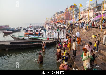 Pilgrims on the bathing ghats beside the Ganges in Varanasi Stock Photo