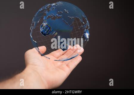 Floating globe over a hand against a dark background-global network concept Stock Photo