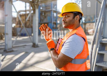 Young worker dressed in safety equipment inside factory Stock Photo