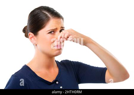 Gross. Studio shot of a young woman holding her nose isolated on white. Stock Photo