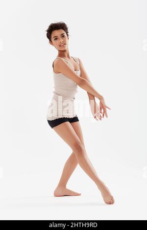 She is such a talent. A pretty teenage girl dancing against a white background. Stock Photo