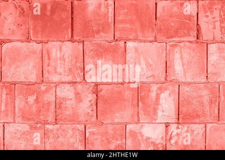 Stone wall of square blocks, coral toned. Background Texture. Stock Photo