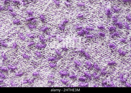 Texture of the knitted fabric. Knitting from yarn, handmade. A pattern of color white and purple yarn, background. Stock Photo