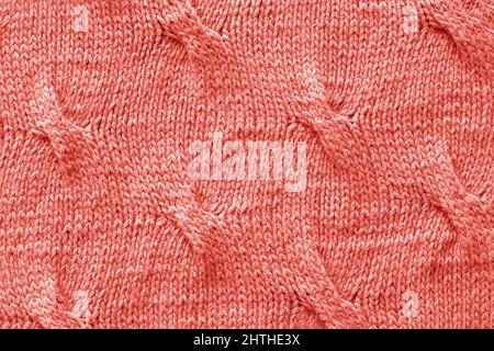 Knitted Jersey fabric textile trendy toned coral color of the year 2019, background, texture. Stock Photo
