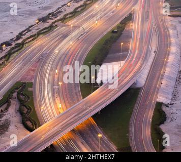 Aerial view of a multi level road crossing during evening hour with trails of traffic lights. Stock Photo