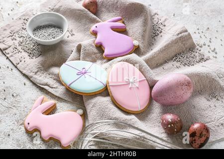 Tasty Easter cookies and painted eggs on light background Stock Photo