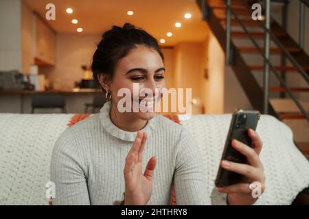Caucasian female relaxing on sofa talking on cellular device Stock Photo
