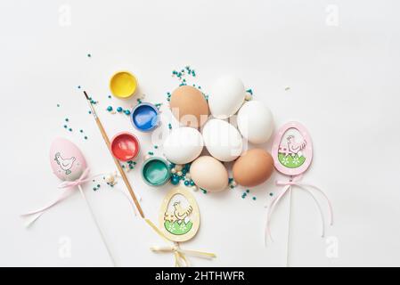 Template in easter theme with eggs and paint on white background Stock Photo