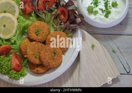 Falafel with salad, lemon slices and yogurt dip, healthy vegetarian meal, high angle view from above, selected focus Stock Photo