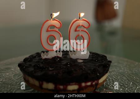 Birthday cake. Birthday cake with burning candle number 66. Stock Photo