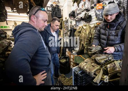 Picture shows Ukrainian men buying army surplus at G4 Echelon Military Supplies ahead of signing up in the UK to head out to fight the Russians in Ukr Stock Photo