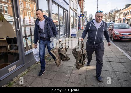 Picture shows Ukrainian men walking down the high street after buying army surplus at G4 Echelon Military Supplies ahead of leaving the UK to fight th Stock Photo