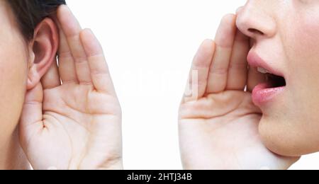 This is just between us. Cropped image of a one woman telling another woman a secret. Stock Photo