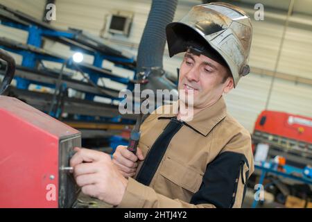 man welding steel tank in factory Stock Photo