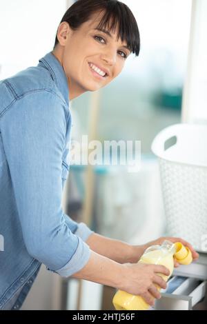 woman hand loading dirty clothes in washing machine Stock Photo