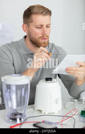 young repairman fixing and repairing blender Stock Photo