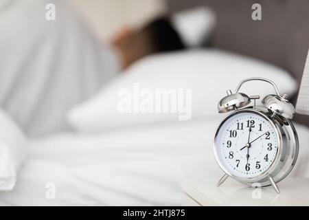 Wake Up Time. Vintage Alarm Clock Standing On Bedside Table In Bedroom Stock Photo