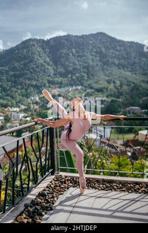 Young fit ballerina in pointes against mountainous landscape Ballerina dancing Stock Photo