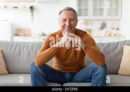 Mature man having rest at home on the couch Stock Photo