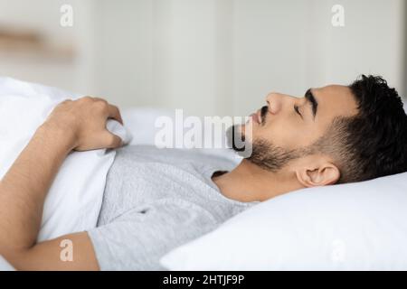 Deep Sleep. Closeup Shot Of Young Arab Man Sleeping In Bed Stock Photo