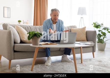 Mature man having video call using laptop and talking Stock Photo