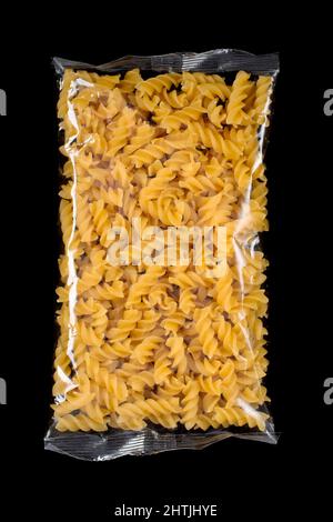 Fusili pasta in plastic package isolated in black background. Stock Photo