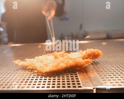 Freshly fried fish in crispy golden batter, at Compo's fish and chip restaurant and takeaway, Holmfirth, West Yorkshire. Stock Photo
