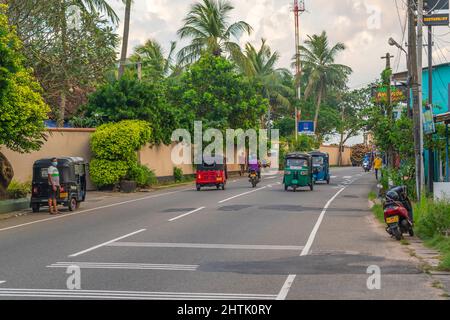 HIKKADUWA, SRI LANKA - DECEMBER 17.2021: Street view in Hikkaduwa with Tuk Tuks at the main road Stock Photo