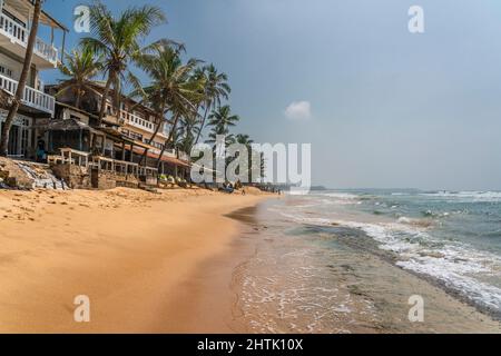HIKKADUWA, SRI LANKA - JANUARY 22, 2022: Unidentified people on the beach at Hikkaduwa. Narigama surfer beach Stock Photo