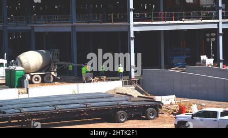 busy construction site background, with constructions workers and equipment, builder car, Bar bender fixing steel reinforcement truck transportation. Stock Photo