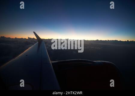 aircraft wing and engine flying over clouds just after sunset above Lanzarote, canary islands, spain Stock Photo