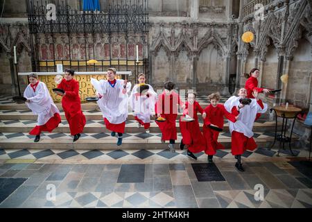 Picture dated February 28th shows Choristers from Ely Cathedral in Cambridgeshire having a practice runout for   Shrove Tuesday Pancake Race.   Choristers at Ely Cathedral in Cambridgeshire practised for their annual pancake race this morning (Mon).  The 10 boys and girls wore their red and white cassocks as they flipped pancakes outside the 12th century Cathedral. The youngsters laughed and giggled as they rehearsed for tomorrow’s traditional event and tried to improve their pancake tossing skills. Each year around 20 choristers race down the cathedral’s nave after Evensong. It is the third l Stock Photo