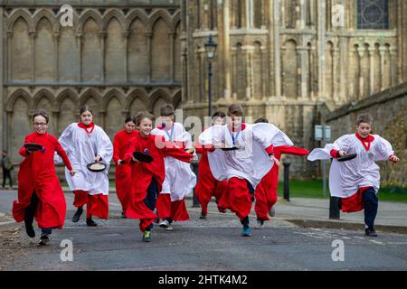 Picture dated February 28th shows Choristers from Ely Cathedral in Cambridgeshire having a practice runout for   Shrove Tuesday Pancake Race.   Choristers at Ely Cathedral in Cambridgeshire practised for their annual pancake race this morning (Mon).  The 10 boys and girls wore their red and white cassocks as they flipped pancakes outside the 12th century Cathedral. The youngsters laughed and giggled as they rehearsed for tomorrow’s traditional event and tried to improve their pancake tossing skills. Each year around 20 choristers race down the cathedral’s nave after Evensong. It is the third l Stock Photo