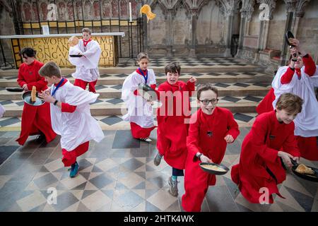 Picture dated February 28th shows Choristers from Ely Cathedral in Cambridgeshire having a practice runout for   Shrove Tuesday Pancake Race.   Choristers at Ely Cathedral in Cambridgeshire practised for their annual pancake race this morning (Mon).  The 10 boys and girls wore their red and white cassocks as they flipped pancakes outside the 12th century Cathedral. The youngsters laughed and giggled as they rehearsed for tomorrow’s traditional event and tried to improve their pancake tossing skills. Each year around 20 choristers race down the cathedral’s nave after Evensong. It is the third l Stock Photo