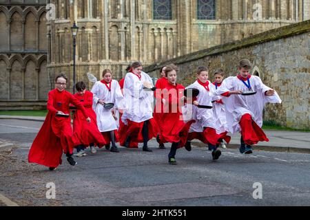 Picture dated February 28th shows Choristers from Ely Cathedral in Cambridgeshire having a practice runout for   Shrove Tuesday Pancake Race.   Choristers at Ely Cathedral in Cambridgeshire practised for their annual pancake race this morning (Mon).  The 10 boys and girls wore their red and white cassocks as they flipped pancakes outside the 12th century Cathedral. The youngsters laughed and giggled as they rehearsed for tomorrow’s traditional event and tried to improve their pancake tossing skills. Each year around 20 choristers race down the cathedral’s nave after Evensong. It is the third l Stock Photo