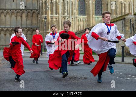 Picture dated February 28th shows Choristers from Ely Cathedral in Cambridgeshire having a practice runout for   Shrove Tuesday Pancake Race.   Choristers at Ely Cathedral in Cambridgeshire practised for their annual pancake race this morning (Mon).  The 10 boys and girls wore their red and white cassocks as they flipped pancakes outside the 12th century Cathedral. The youngsters laughed and giggled as they rehearsed for tomorrow’s traditional event and tried to improve their pancake tossing skills. Each year around 20 choristers race down the cathedral’s nave after Evensong. It is the third l Stock Photo