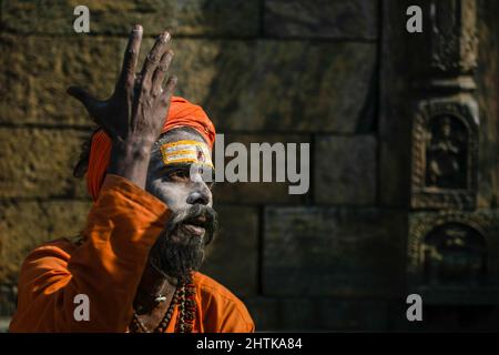 Kathmandu, Nepal. 01st Mar, 2022. A Hindu holy man or sadhu performs rituals at the Pashupatinath Temple premises during the Mahashivaratri festival. Hindu Devotees from Nepal and India come to this temple to take part in the Shivaratri festival which is one of the biggest Hindu festivals dedicated to Lord Shiva and celebrated by devotees all over the world. (Photo by Prabin Ranabhat/SOPA Images/Sipa USA) Credit: Sipa USA/Alamy Live News Stock Photo