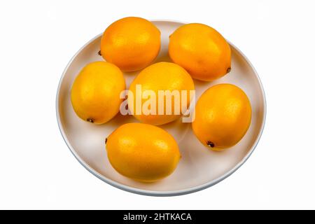 Lemons in round plate on white background Stock Photo