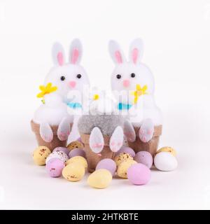 Easter bunnies with little candy chocolate easter eggs isolated on a white background Stock Photo