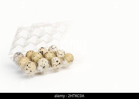 A dozen of quail eggs in a plastic tray on a white background with copy space Stock Photo