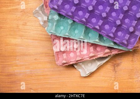 Empty colored cardboard egg tray on a wooden table in a top view Stock Photo