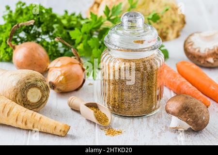 Homemade vegetable broth powder, organic vegetable stock, with raw vegetables on white wooden background Stock Photo