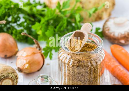 Homemade vegetable broth powder, organic vegetable stock, with raw vegetables on white wooden background, close up Stock Photo