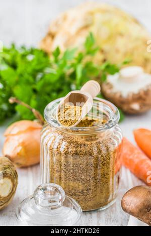 Homemade vegetable broth powder, organic vegetable stock, with raw vegetables on white wooden background, vertical Stock Photo