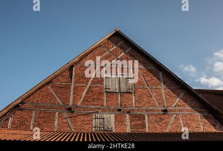 a half-timbered gable at a barn built of red bricks in german countryside Stock Photo